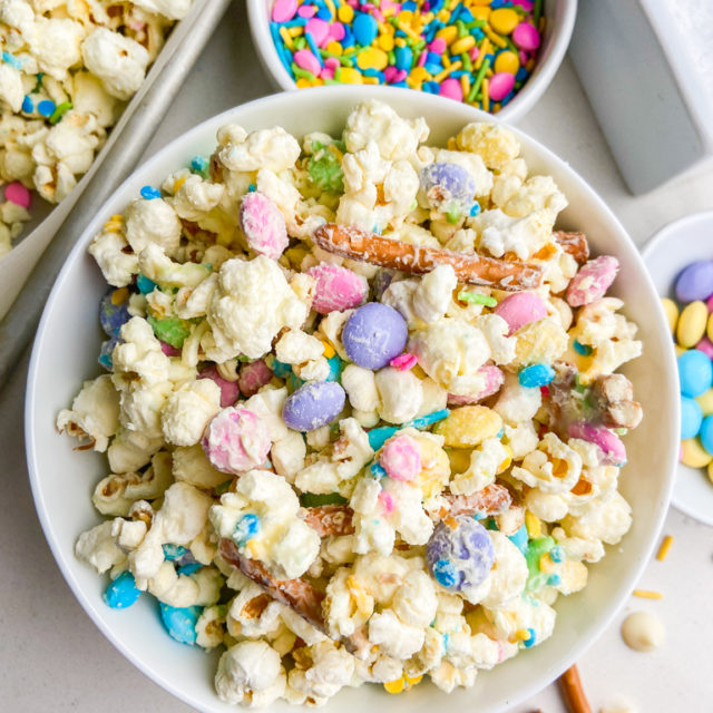 Overhead photo of white chocolate popcorn mix in a white bowl.