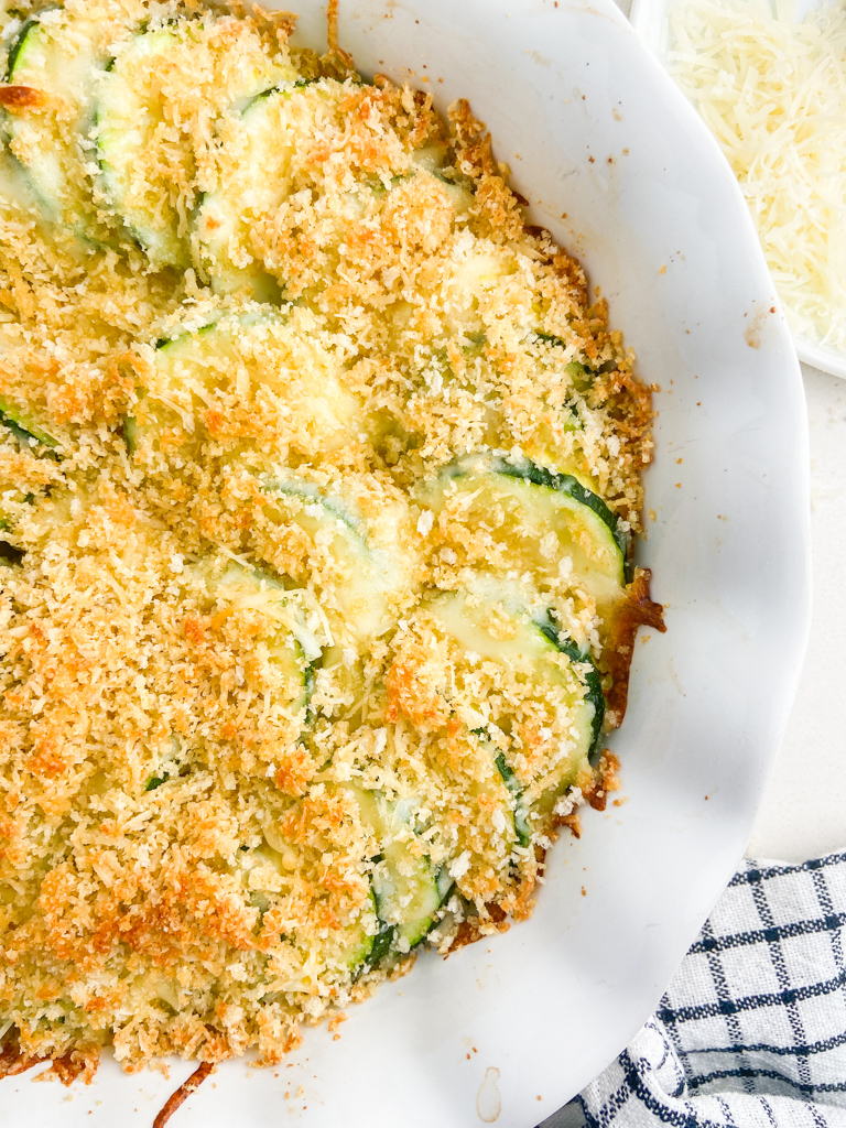 Overhead photo of zucchini casserole in a white scalloped pie dish. 