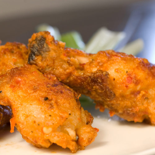 Buffalo chicken wings on white plate.