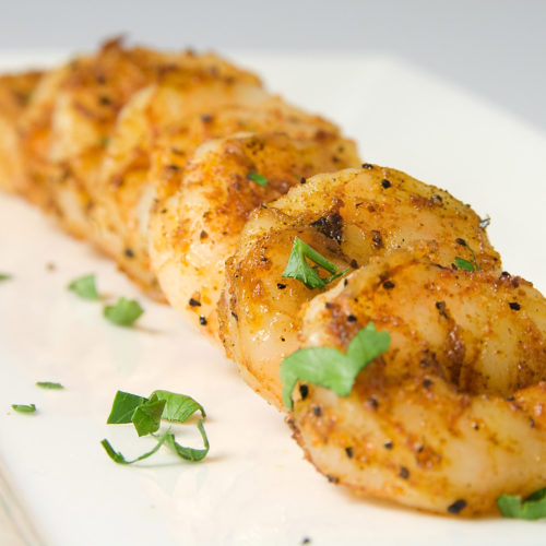 cajun prawns on white plate.