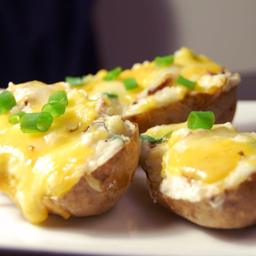 3 twice baked potatoes on white plate.