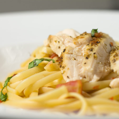 Bowl of chicken linguine with chunky tomato sauce.