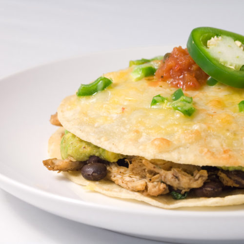 Chicken tortilla stack on white plate.