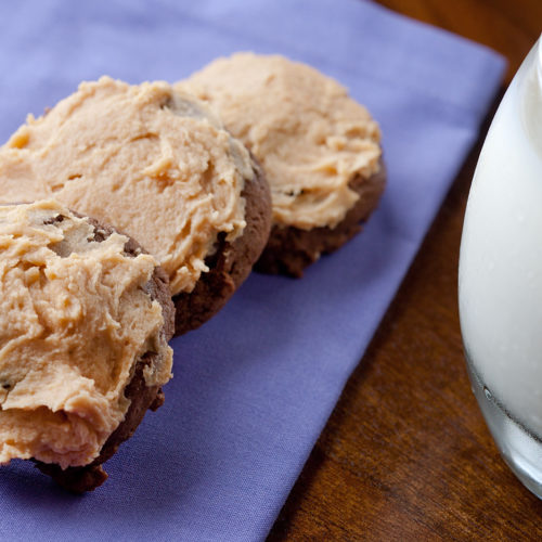 Chocolate cookies with peanut butter frosting on purple napkin