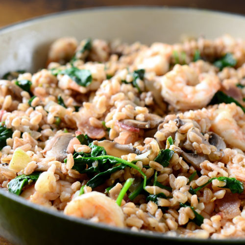 Farro with shrimp bacon and mushrooms in pan.