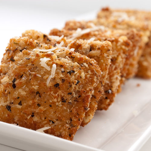 Fried ravioli on white plate.