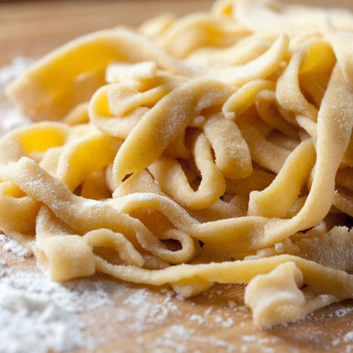 uncooked homemade pasta on cutting board.