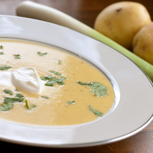 Potato leek soup in white bowl.