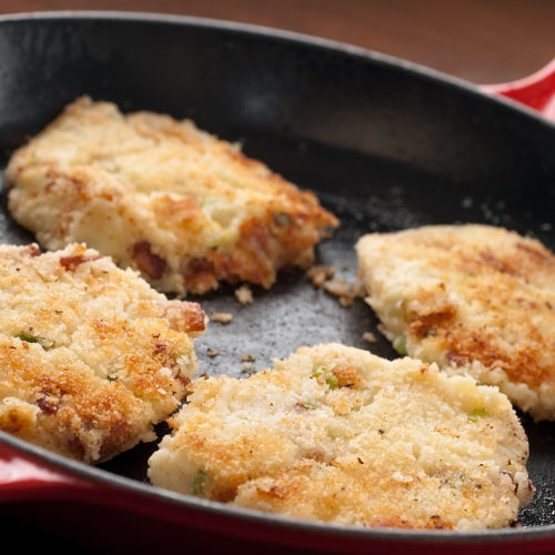 4 potato pancakes in a skillet.