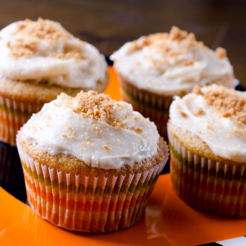 Pumpkin cupcakes with frosting on plate.
