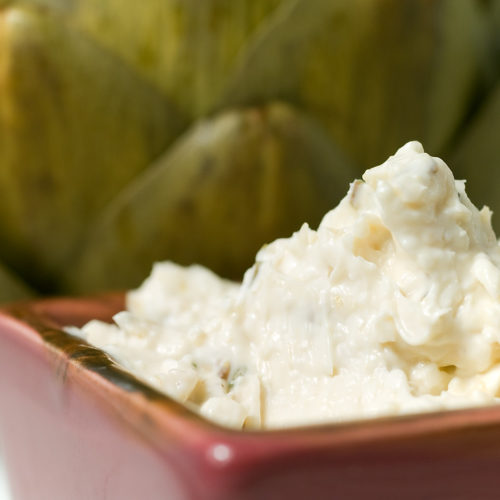 Roasted garlic rosemary dip in square red dish.