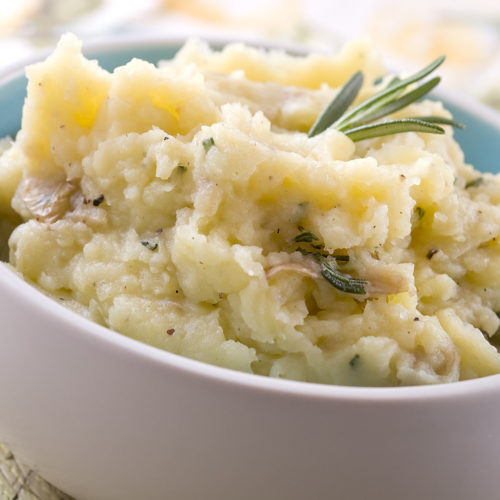 Rosemary mashed potatoes in white bowl.