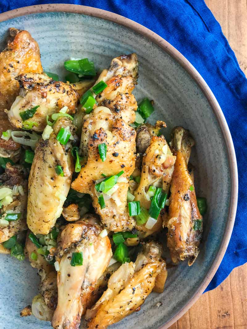 Baked Salt and Pepper Chicken wings are baked until crispy and tossed in a mixture of sesame oil, jalapeños, garlic and green onions.