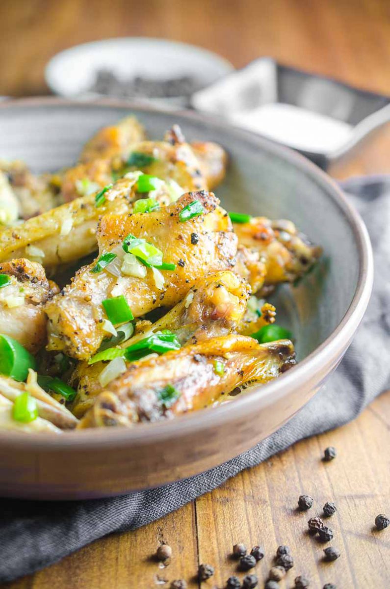 Baked Salt and Pepper Chicken wings are baked until crispy and tossed in a mixture of sesame oil, jalapeños, garlic and green onions.