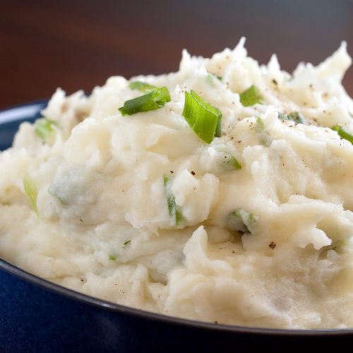 scallion buttermilk mashed potatoes in blue bowl.