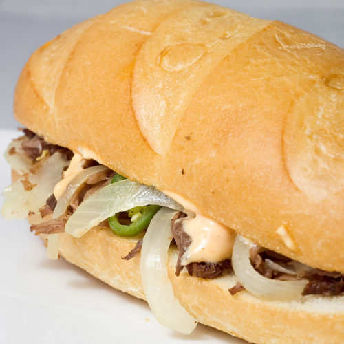 shredded beef sandwich on white plate.