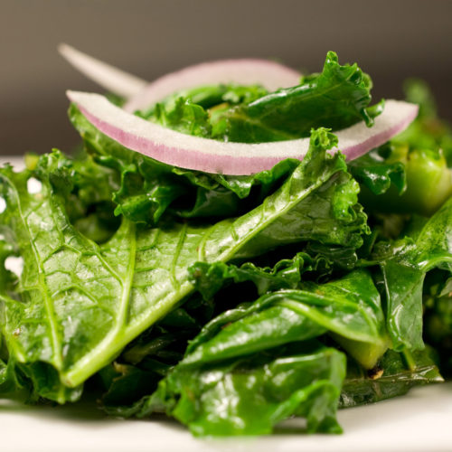 Close up of kale on white plate.