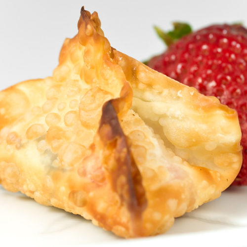 A single strawberry nutella wonton on white plate with strawberry.
