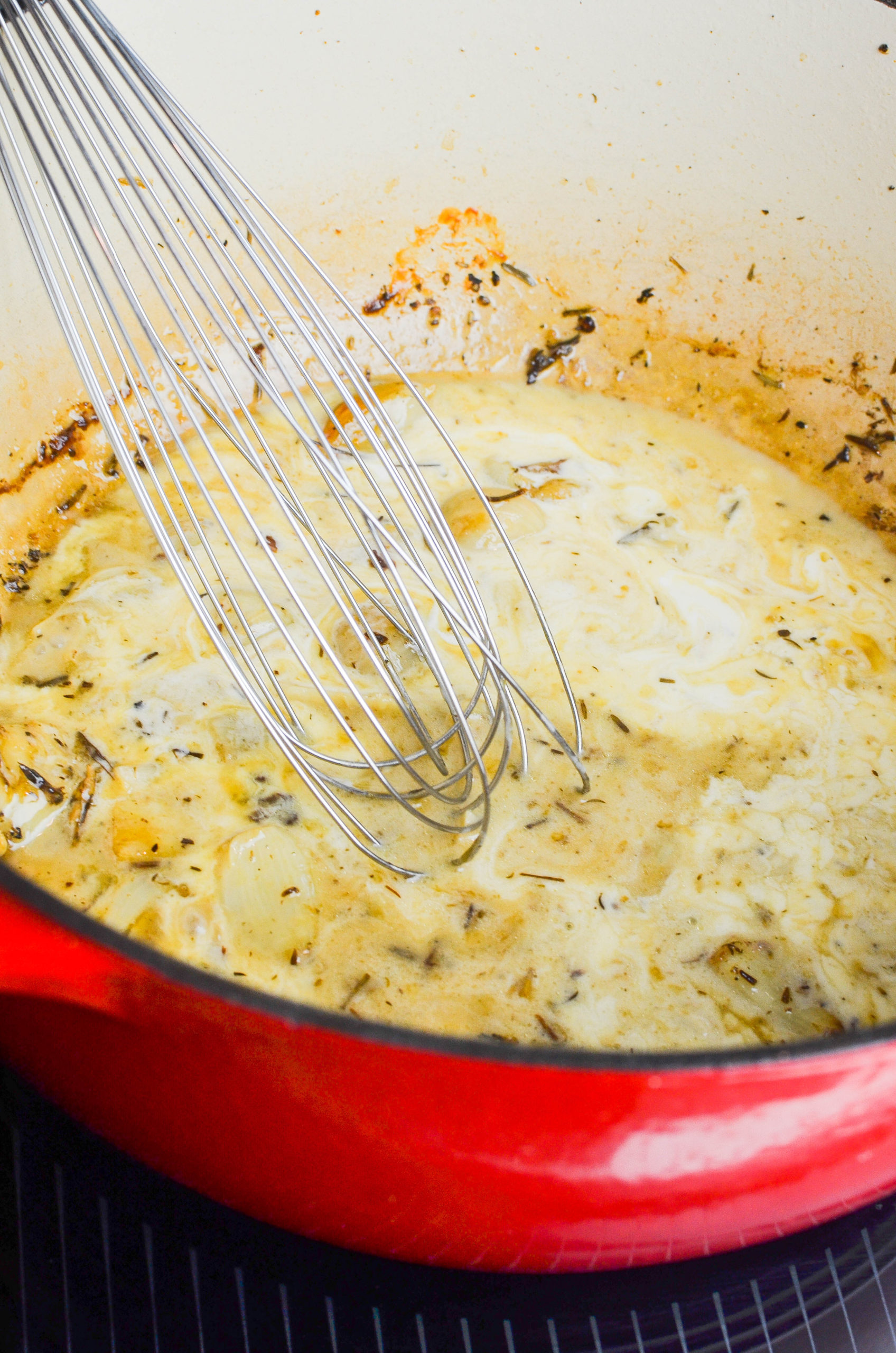 Whisking heavy cream into garlic chicken sauce. 