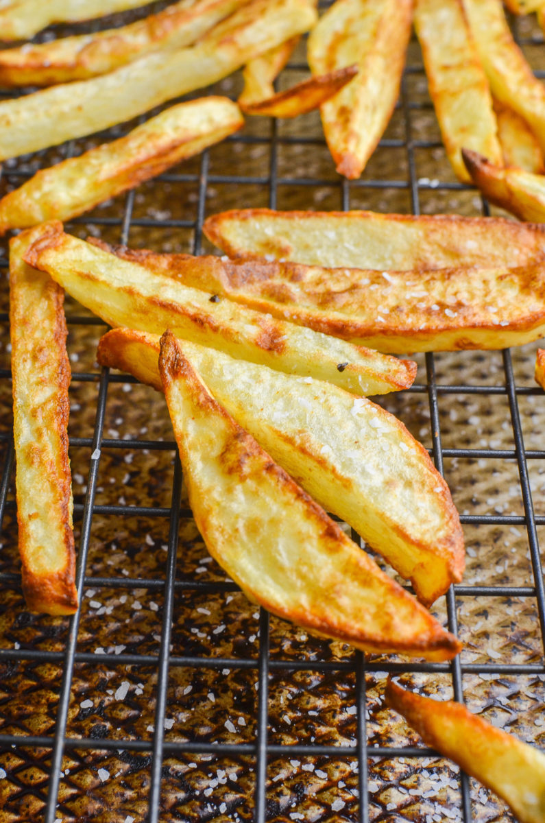 French fries on a wire rack on a baking sheet. 