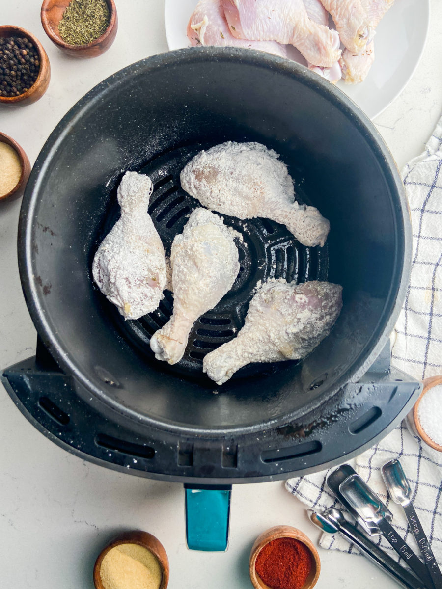 Flour coated fried chicken in air fryer basket. 