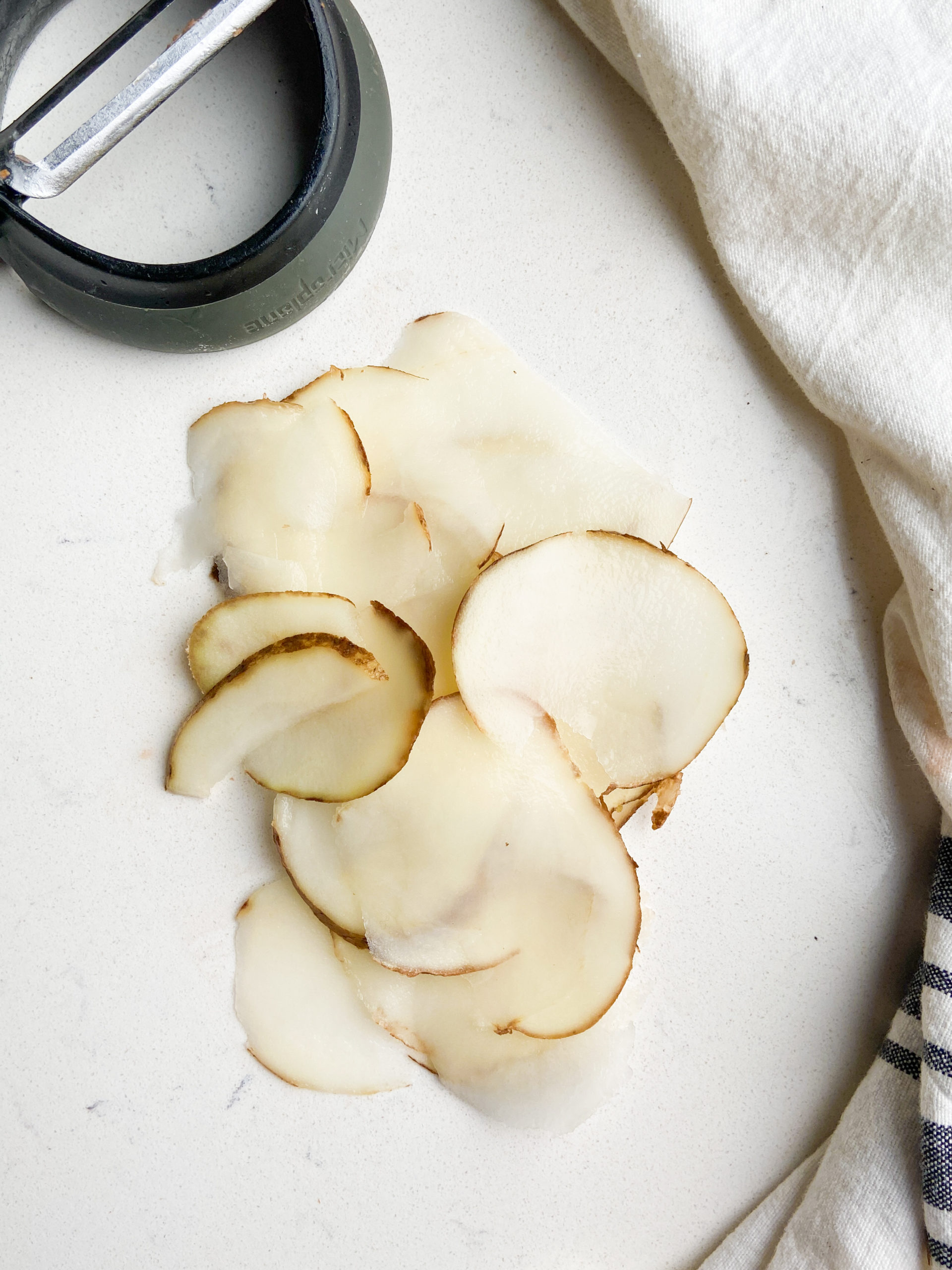 Potato slices cut with vegetable peeler. 
