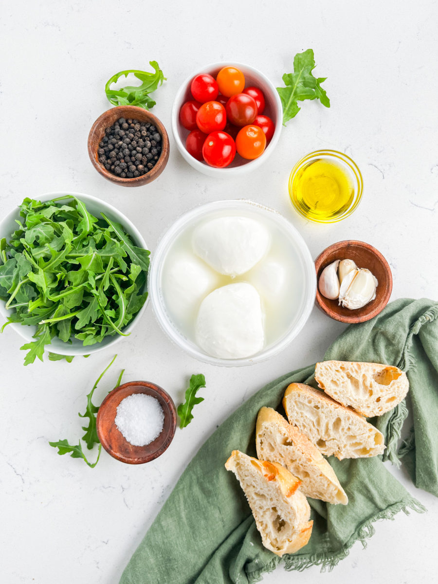 Arugula burrata salad ingredients on white background. 