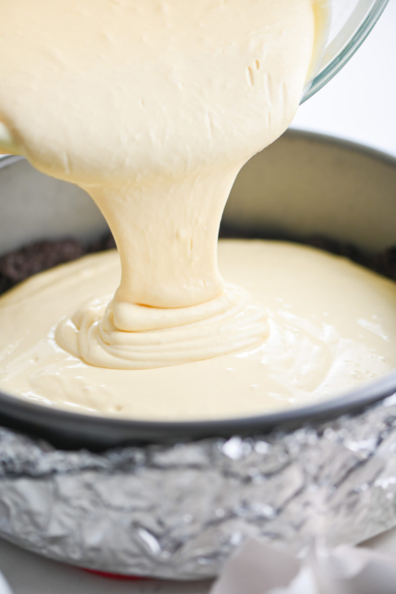 Pouring cheesecake into springform pan. 