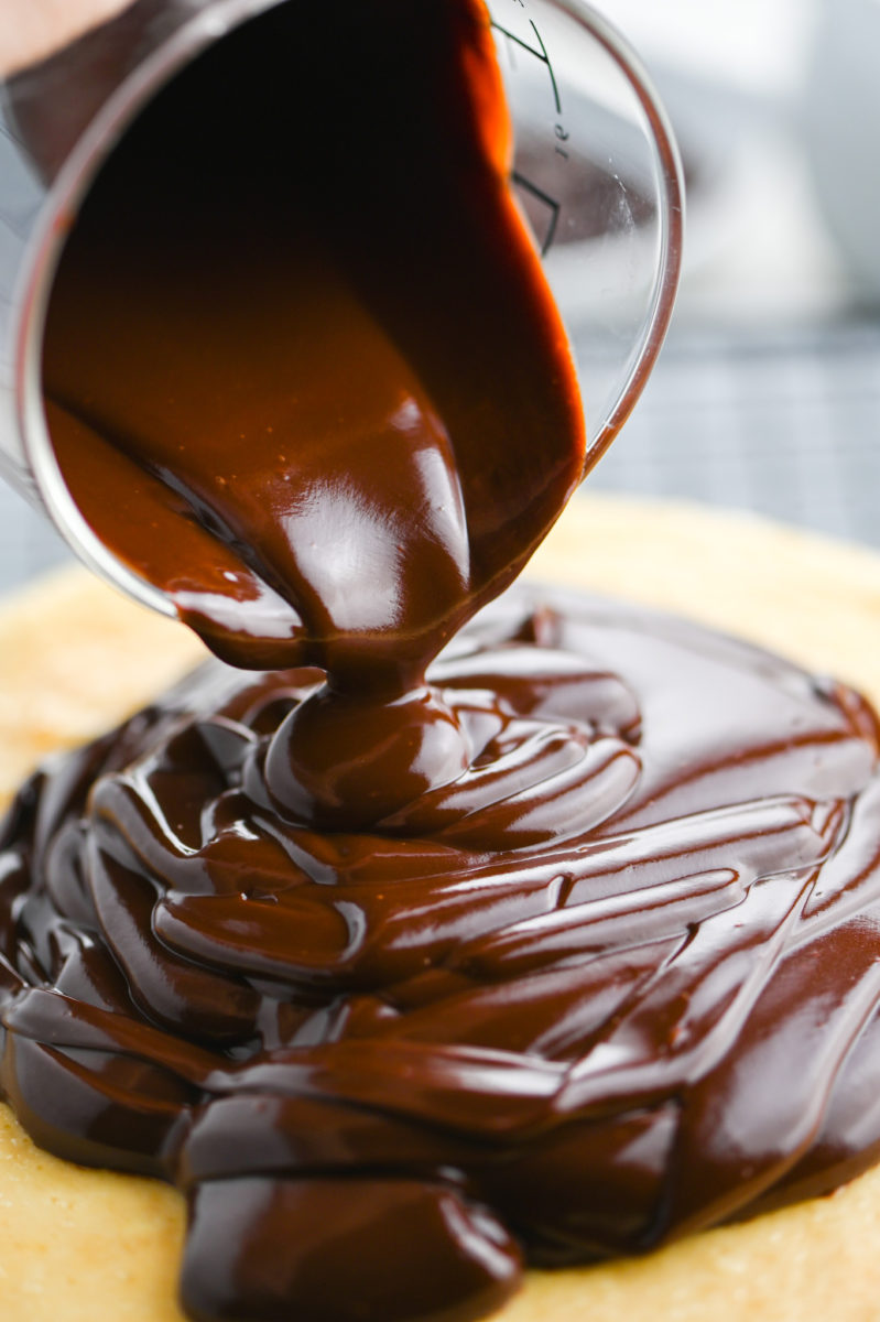 Pouring chocolate ganache on cheesecake. 