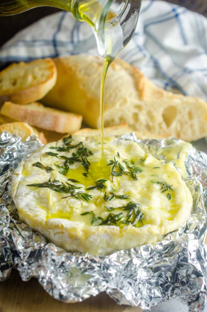 Baked camembert cheese studded with fresh garlic, thyme and a drizzle of olive oil. It's a cheese lover's dream! Serve with crackers and crostini.