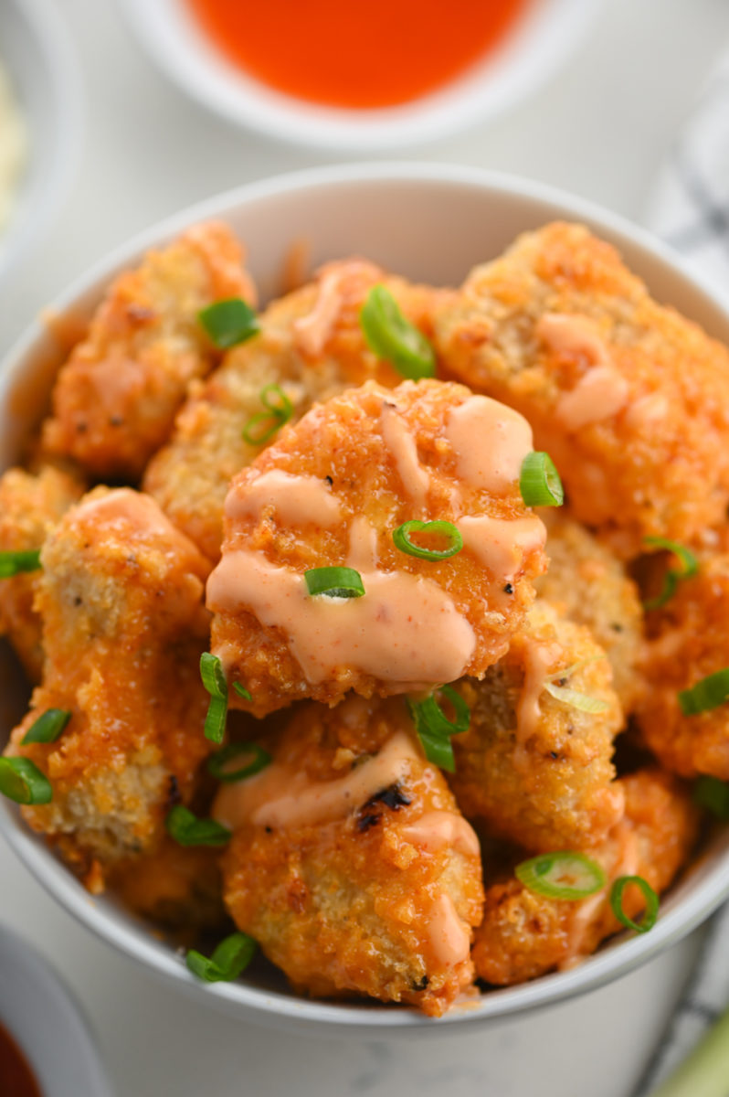 Close up photo of bang bang chicken garnished with green onions. 