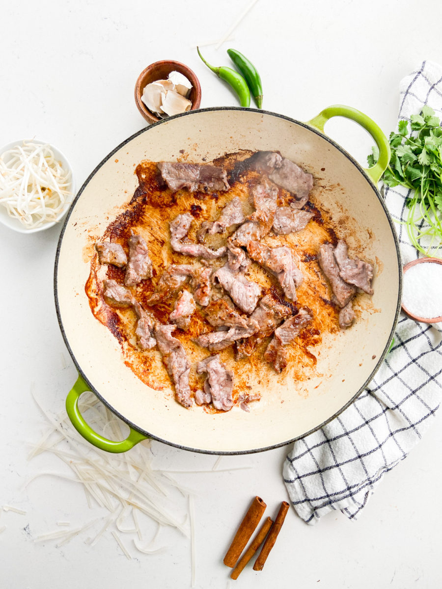 Browning steak slices in skillet. 