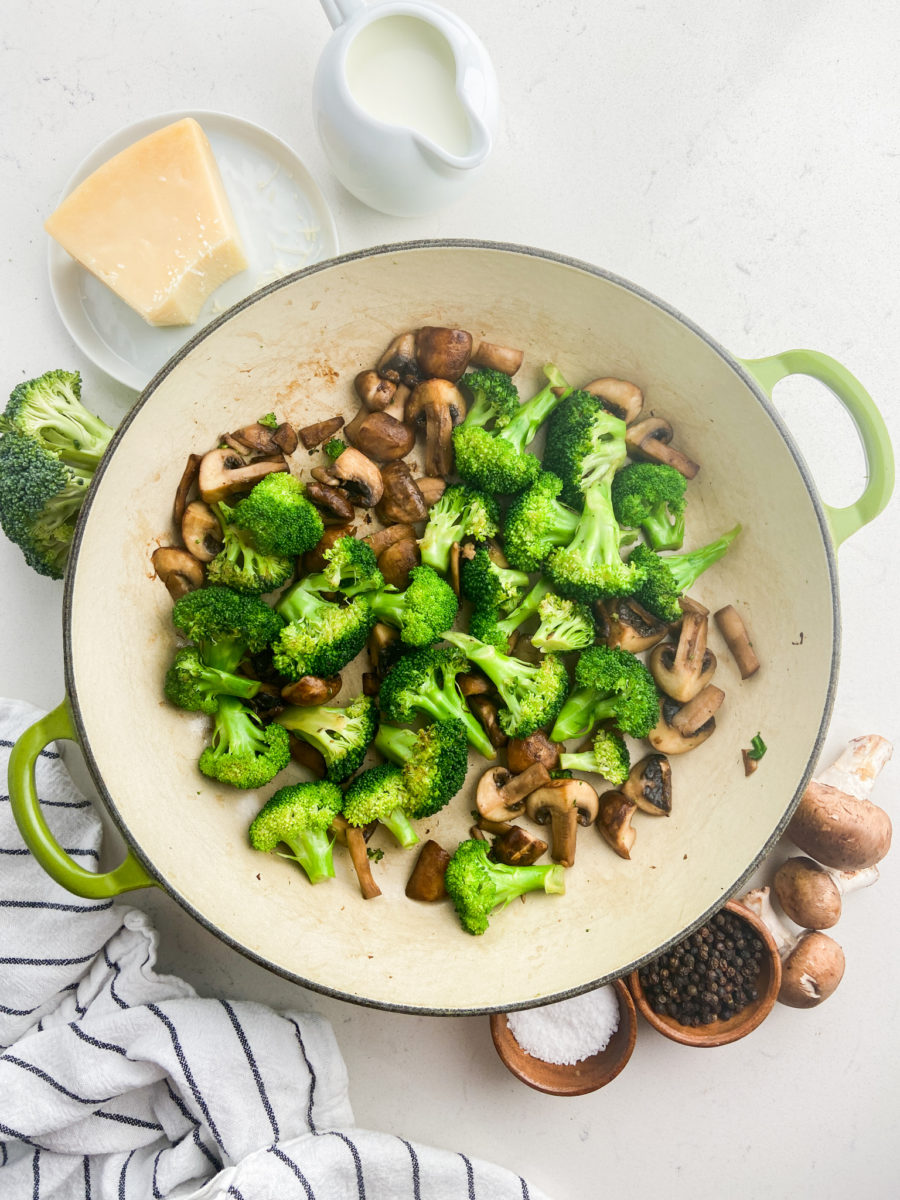Sauteed broccoli and mushrooms in pan.  