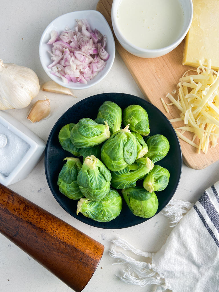 Overhead photo ingredients with Brussels Sprouts on a black plate. 