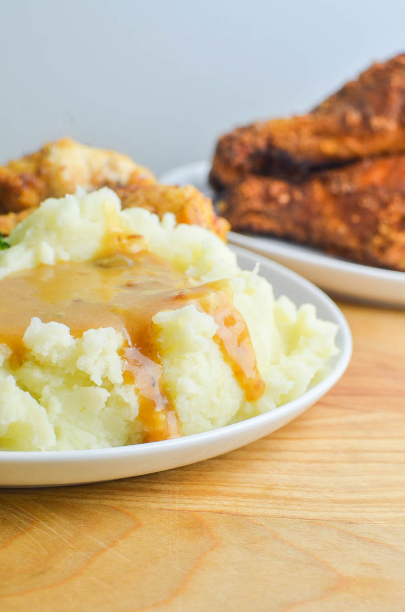 Mashed potatoes and gravy on a white plate. 