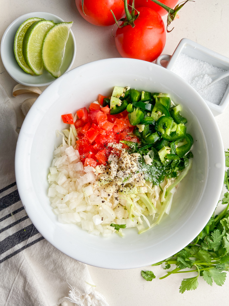 Overhead photo of cabbage salsa ingredients in white bowl. 