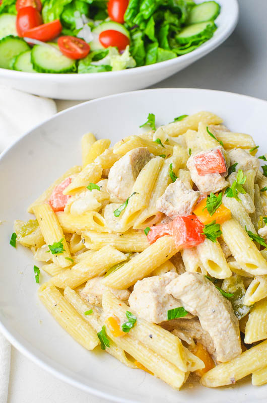 Side view of caribbean jerk chicken pasta pasta in a white bow.. 