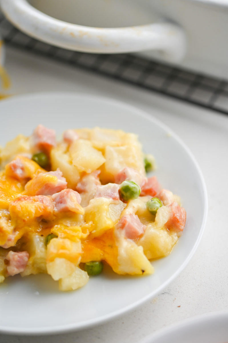 Ham potato casserole on white plate.