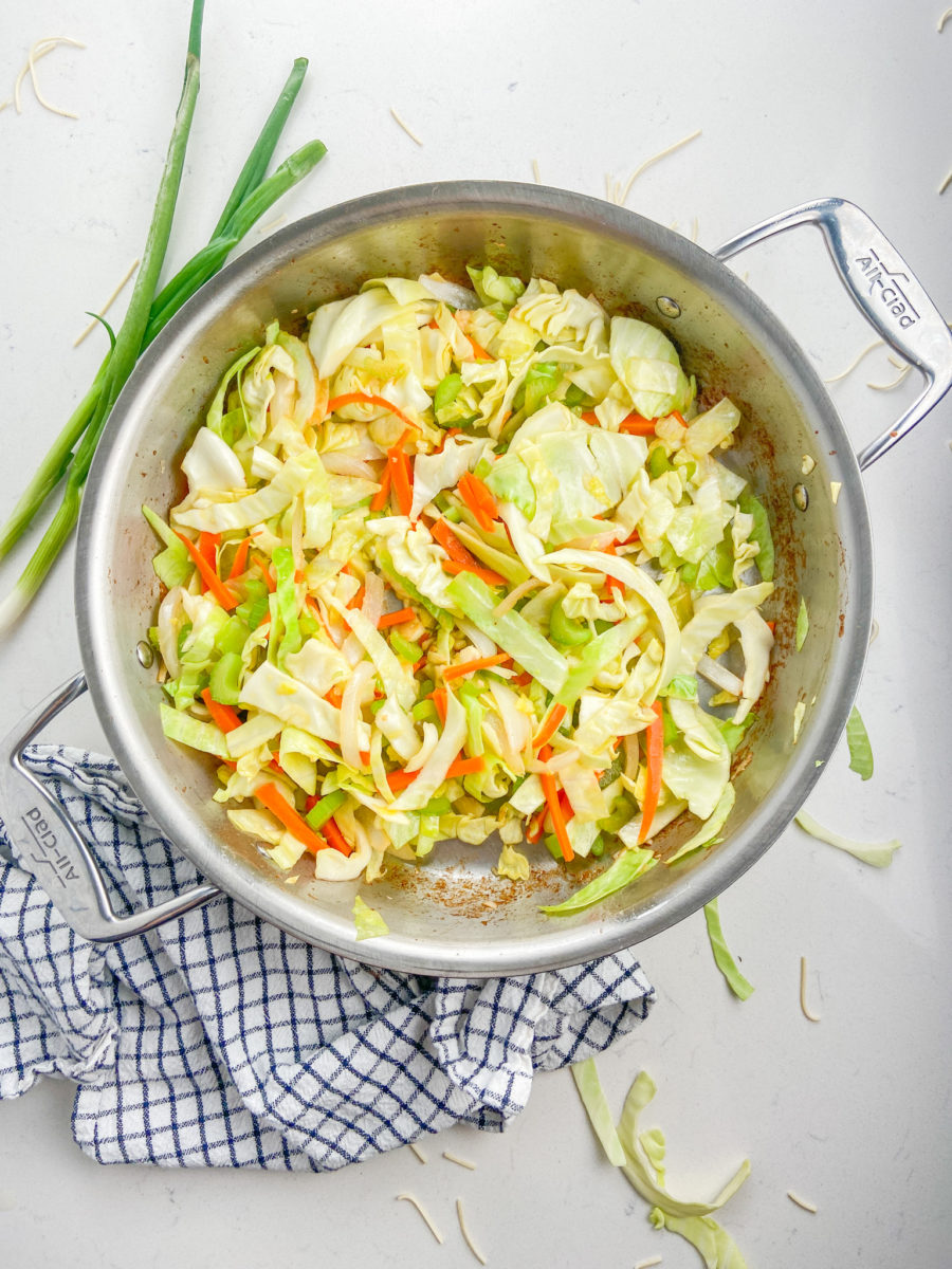 Stir fry vegetables in a stainless steel pan. 