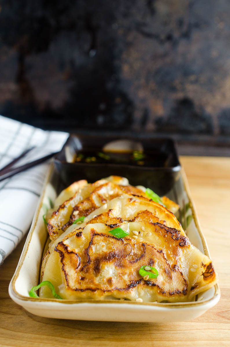 Chicken potstickers on a long rectangular plate. 