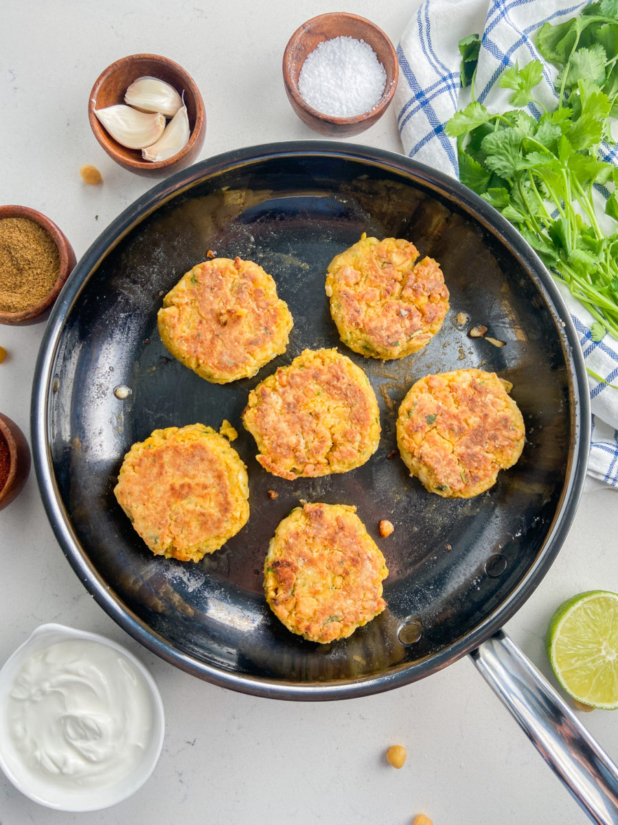 Chickpea fritters frying in a pan. 