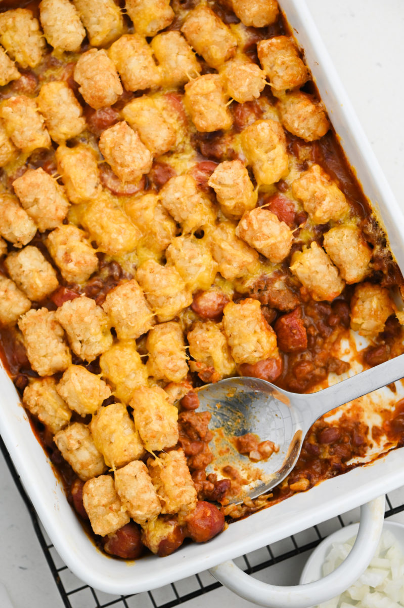 Overhead photo of tater tot casserole in baking dish with silver spoon.