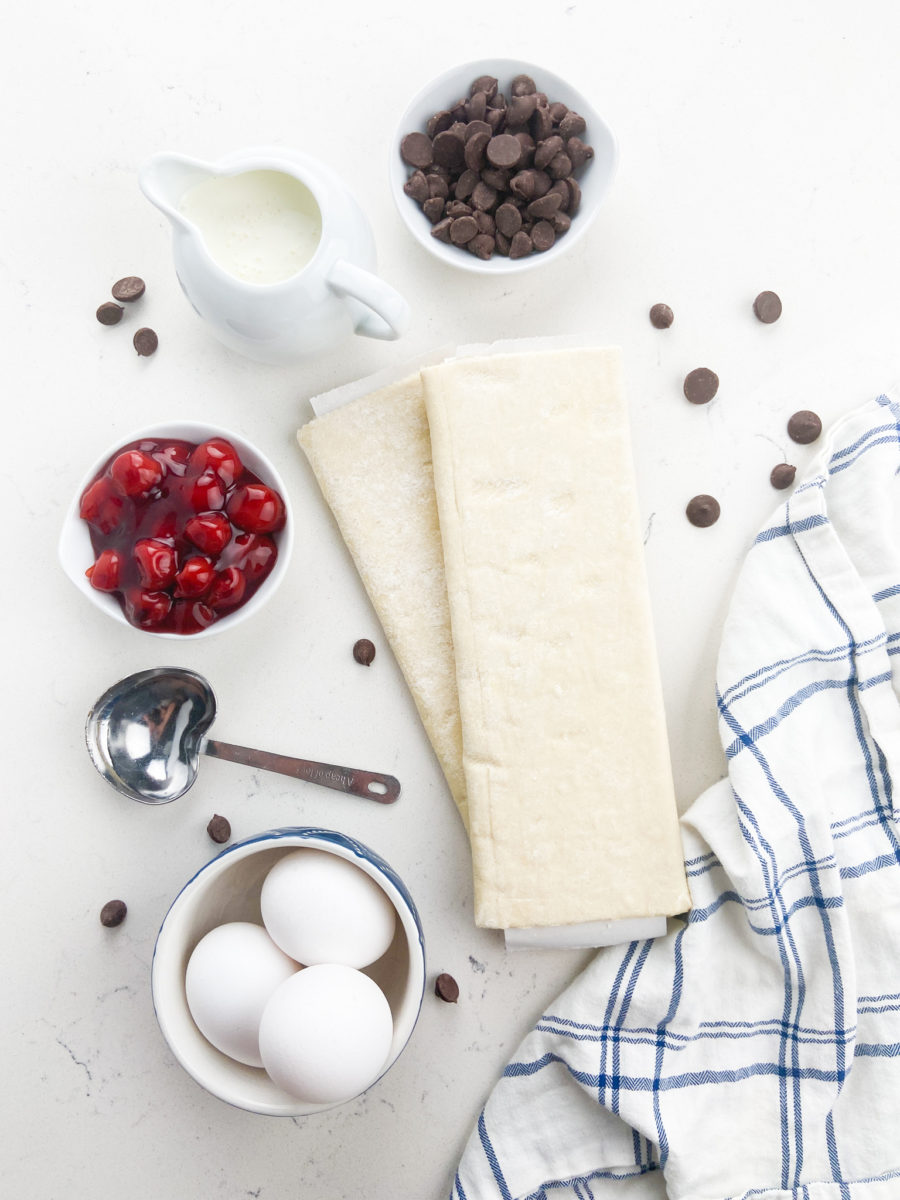 Ingredients for cherry turnovers on white background with white and blue napkin. 