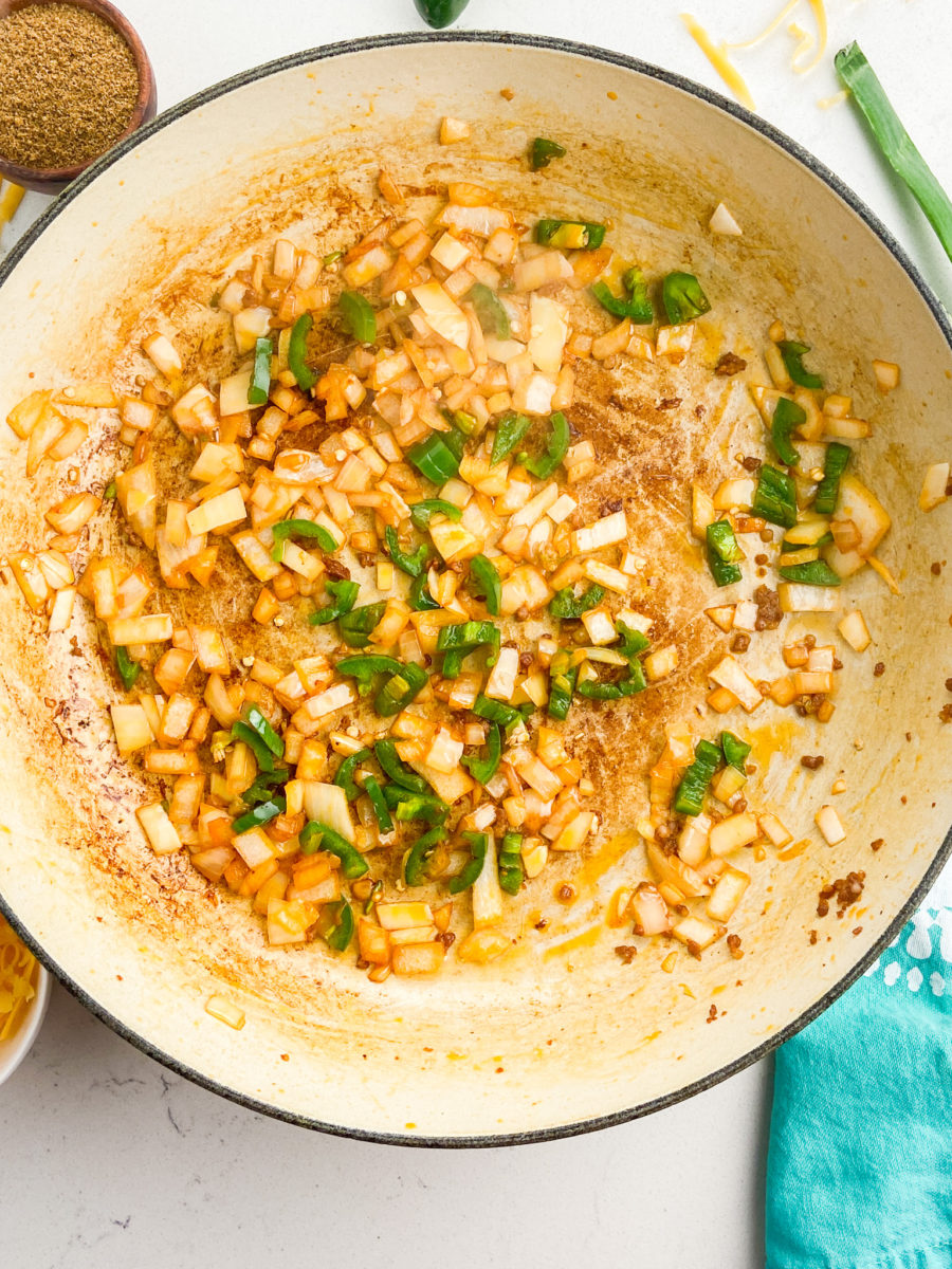 Cooking jalapenos and onions in pan. 