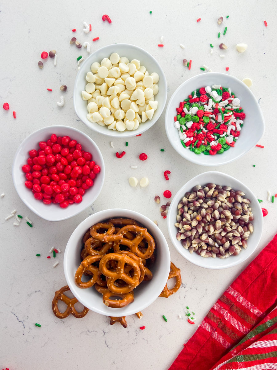 Christmas popcorn ingredients in white bowls. 