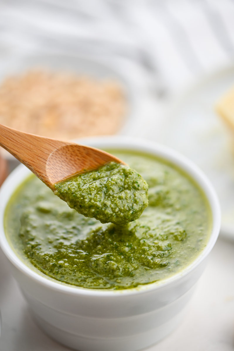 A wooden spoonful of basil pesto.