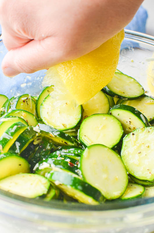 Squeezing lemon juice on zucchini. 