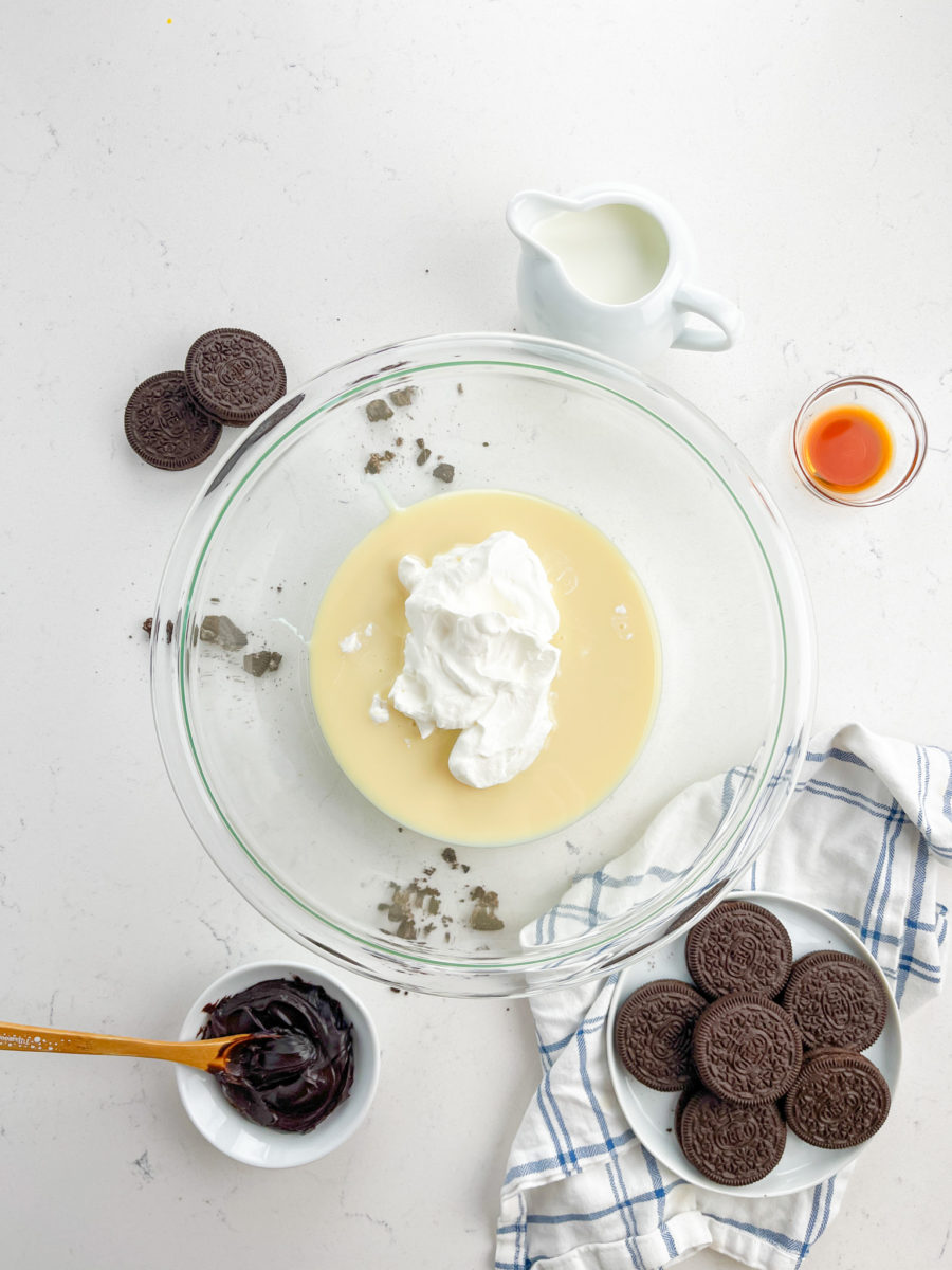 Sweetened condensed milk and scoop of whipped cream in glass bowl. 
