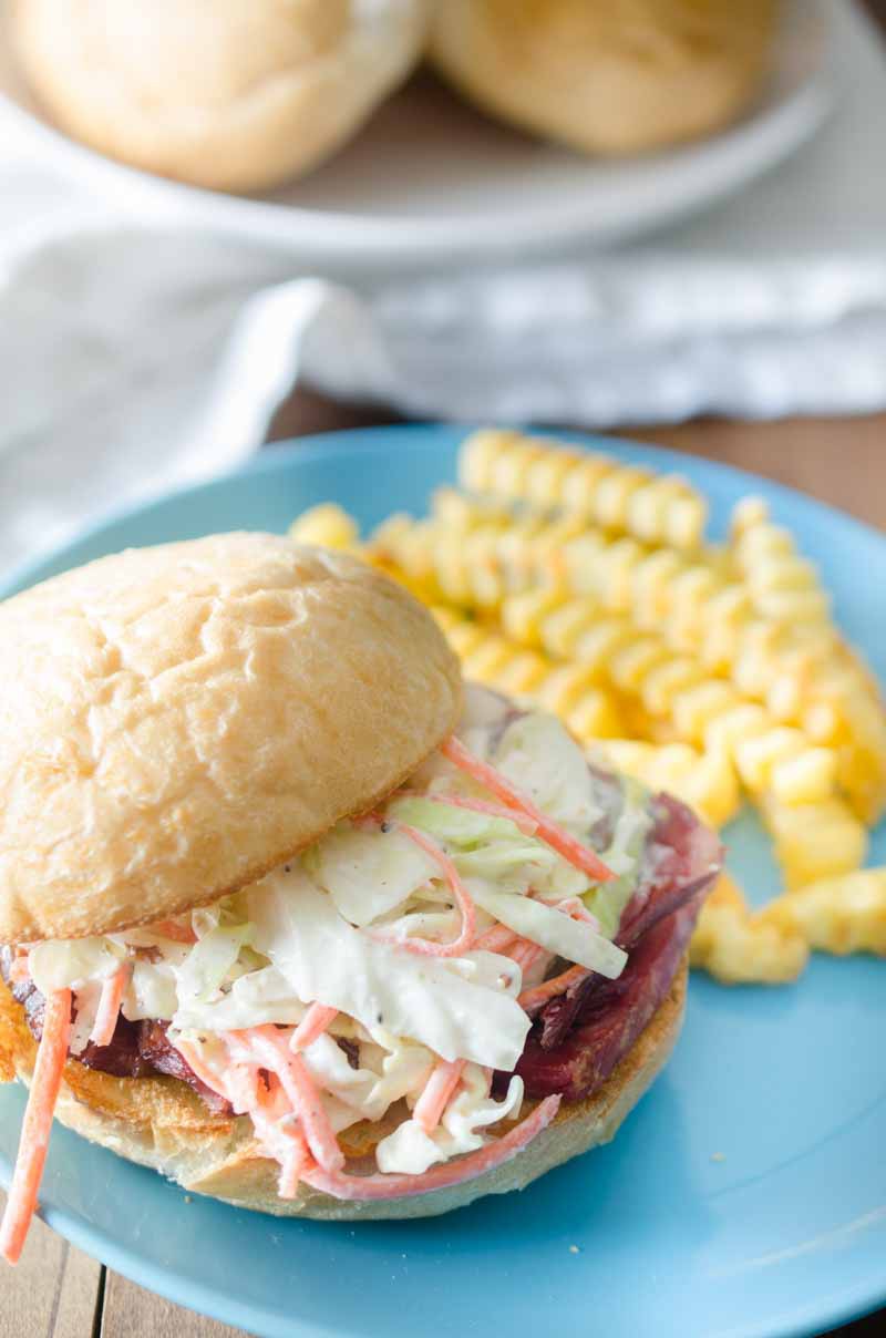 Ultimate Corned Beef Sandwiches topped with melted Swiss cheese and a creamy horseradish slaw. 