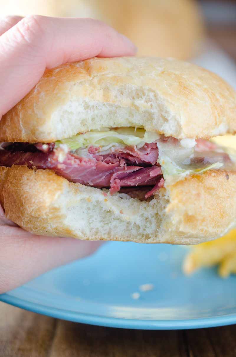 Ultimate Corned Beef Sandwiches topped with melted Swiss cheese and a creamy horseradish slaw. 